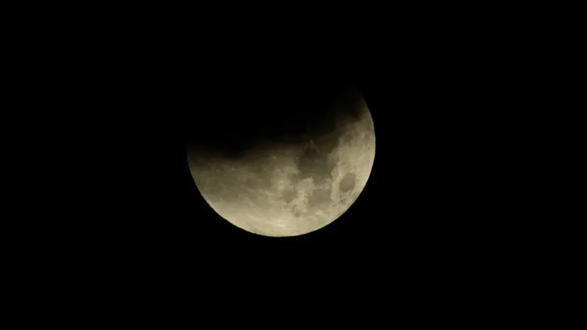 Bulan sabit kemerahan muncul di atas cakrawala barat Kota Madrid saat fajar menyingsing.